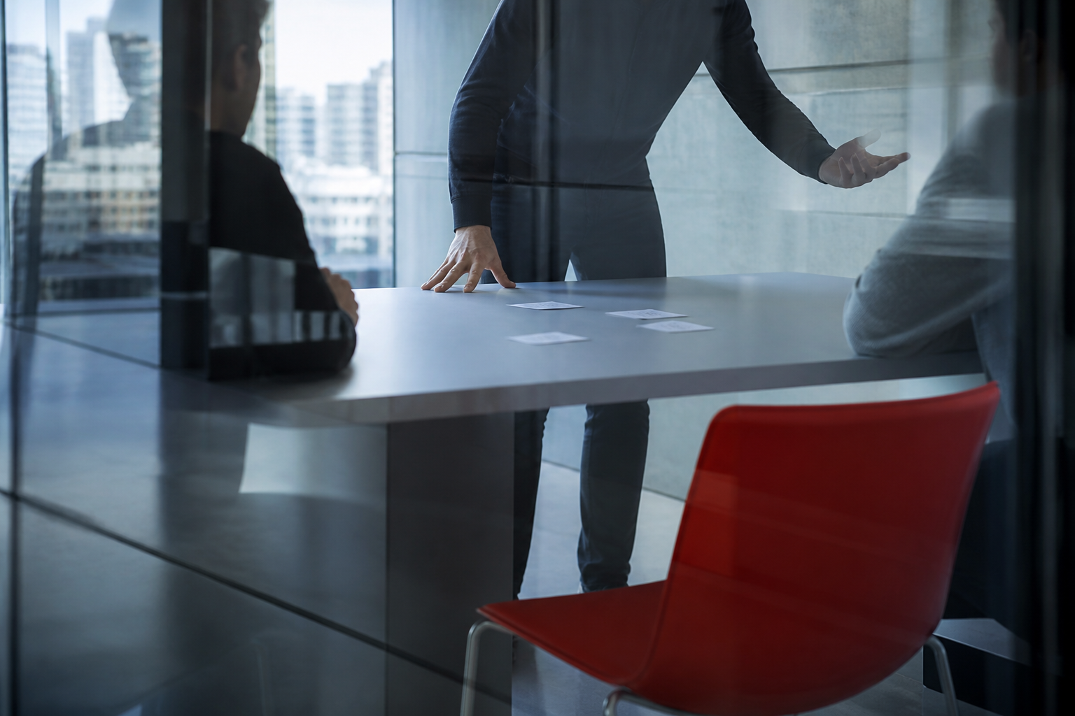 A candid leadership conversation seen through a glass meeting room